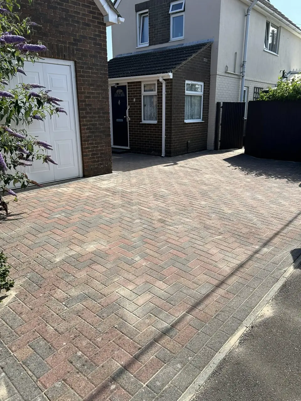Block paving driveway in front of a garage after pressure washing