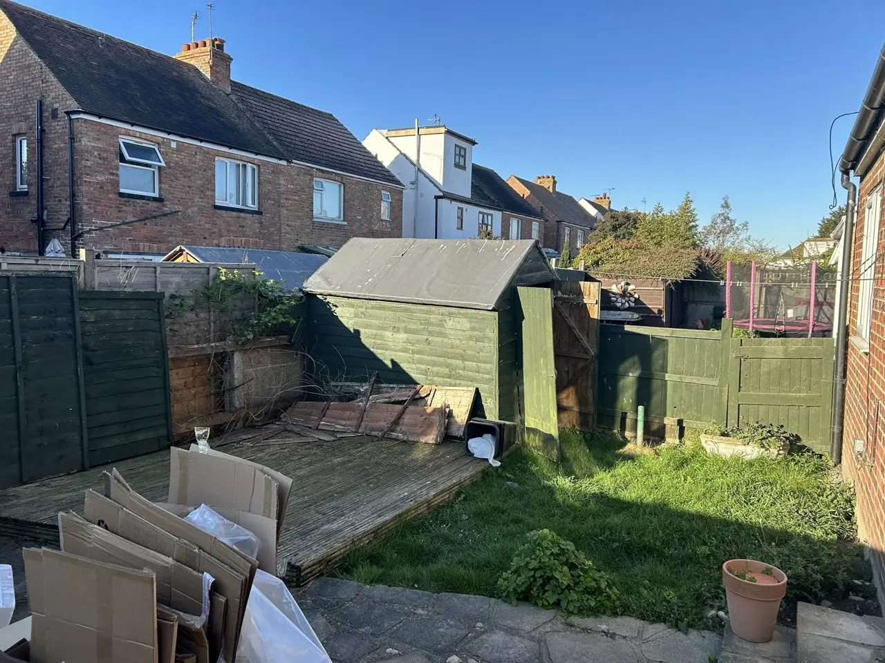 Back garden with an old fence and rubbish before clearance and new fencing