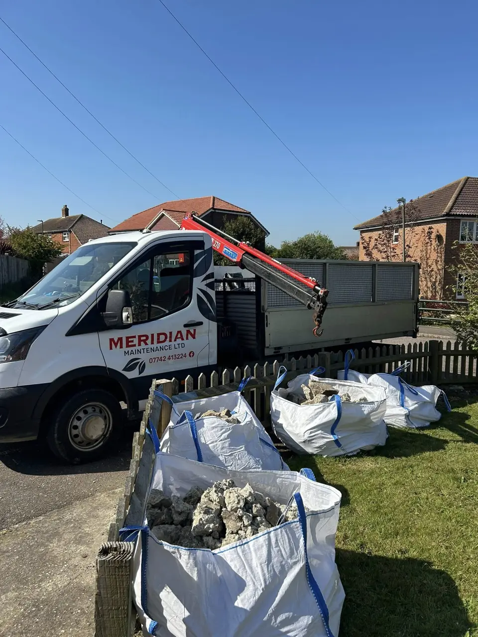 Meridian Maintenance van with a tipper body loaded beside bags of garden waste