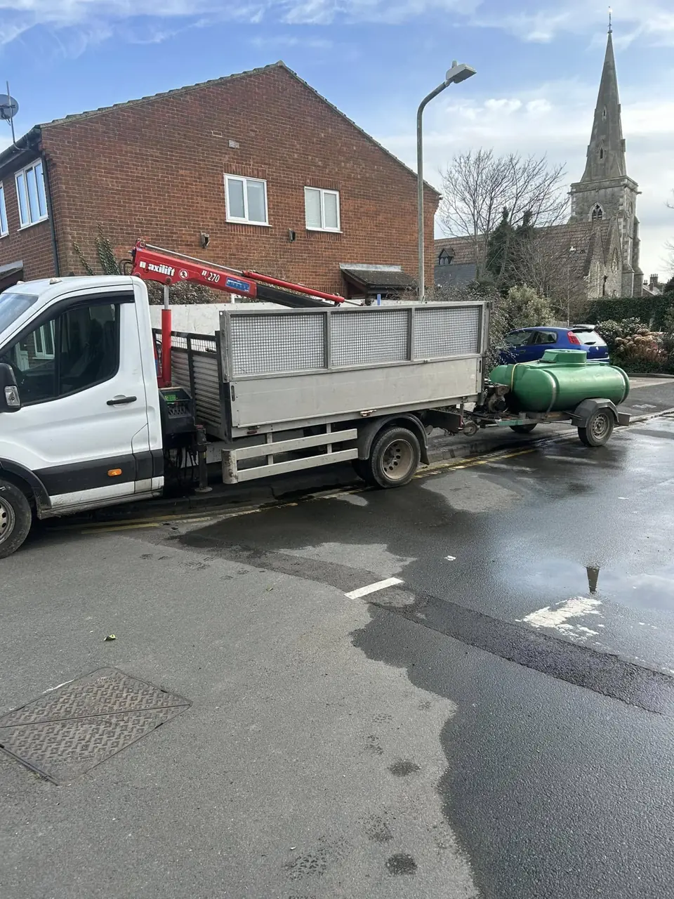 Meridian Maintenance van and tipper parked on a road near a church on a job