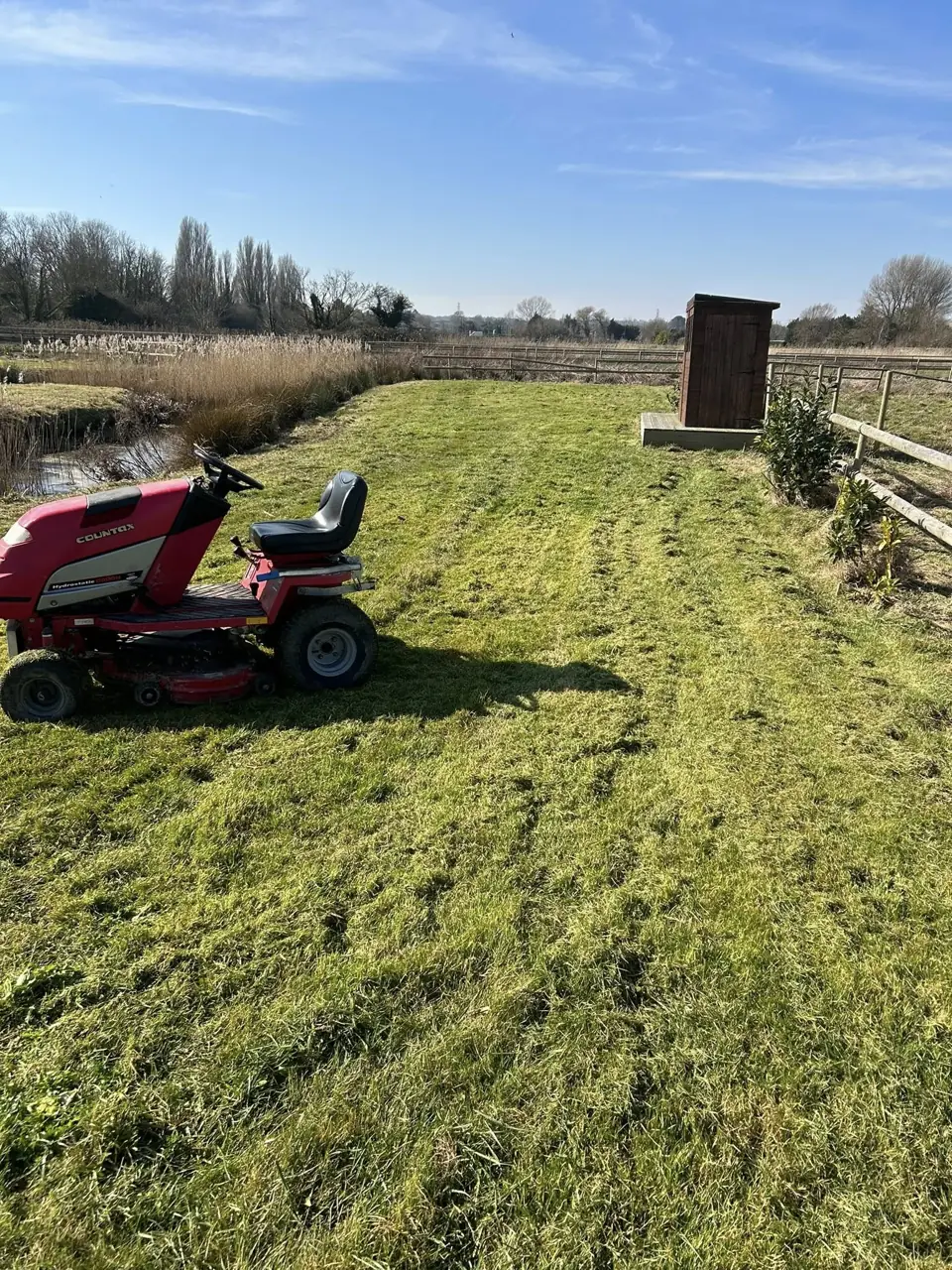 Ride on mower cutting a large open lawn